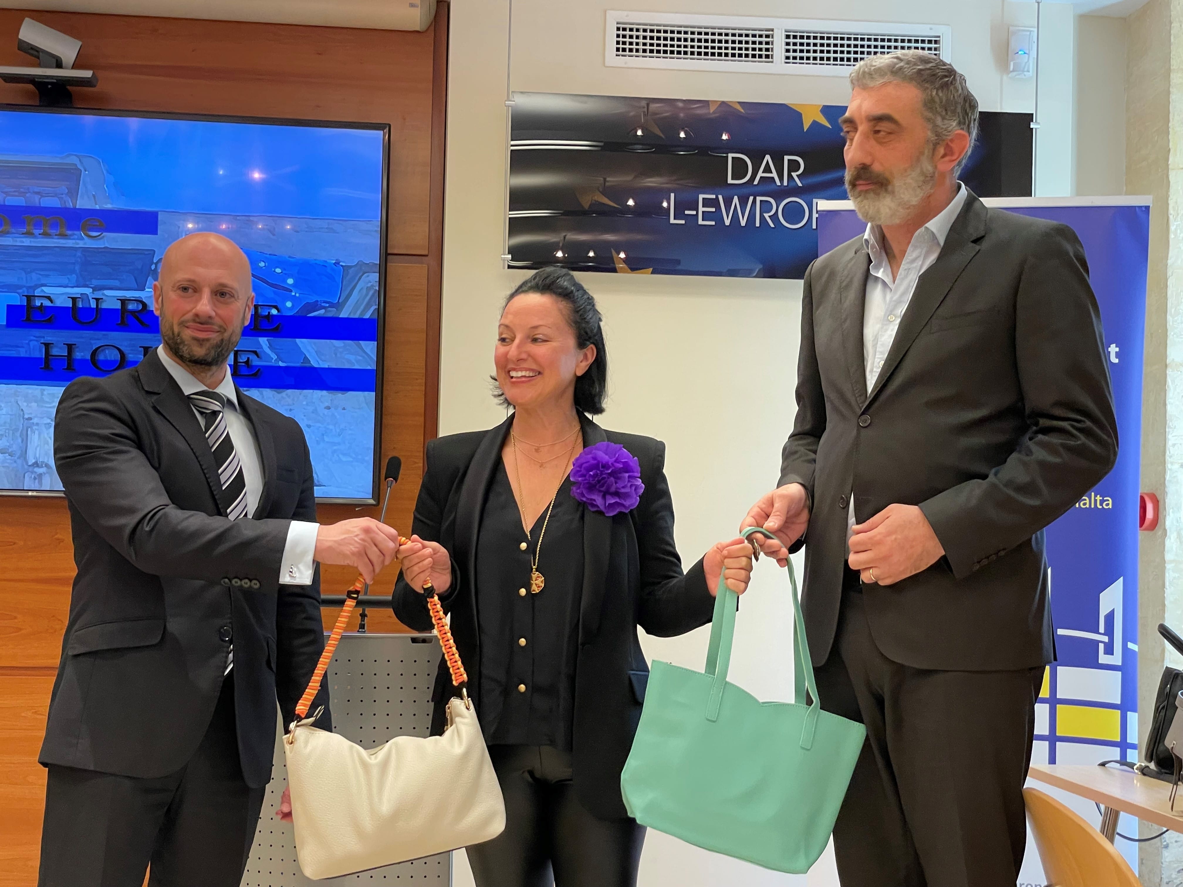 Dana Carmont receiving handbags filled with women's essentials from the European Parliament Office and European Commission Representation in Malta