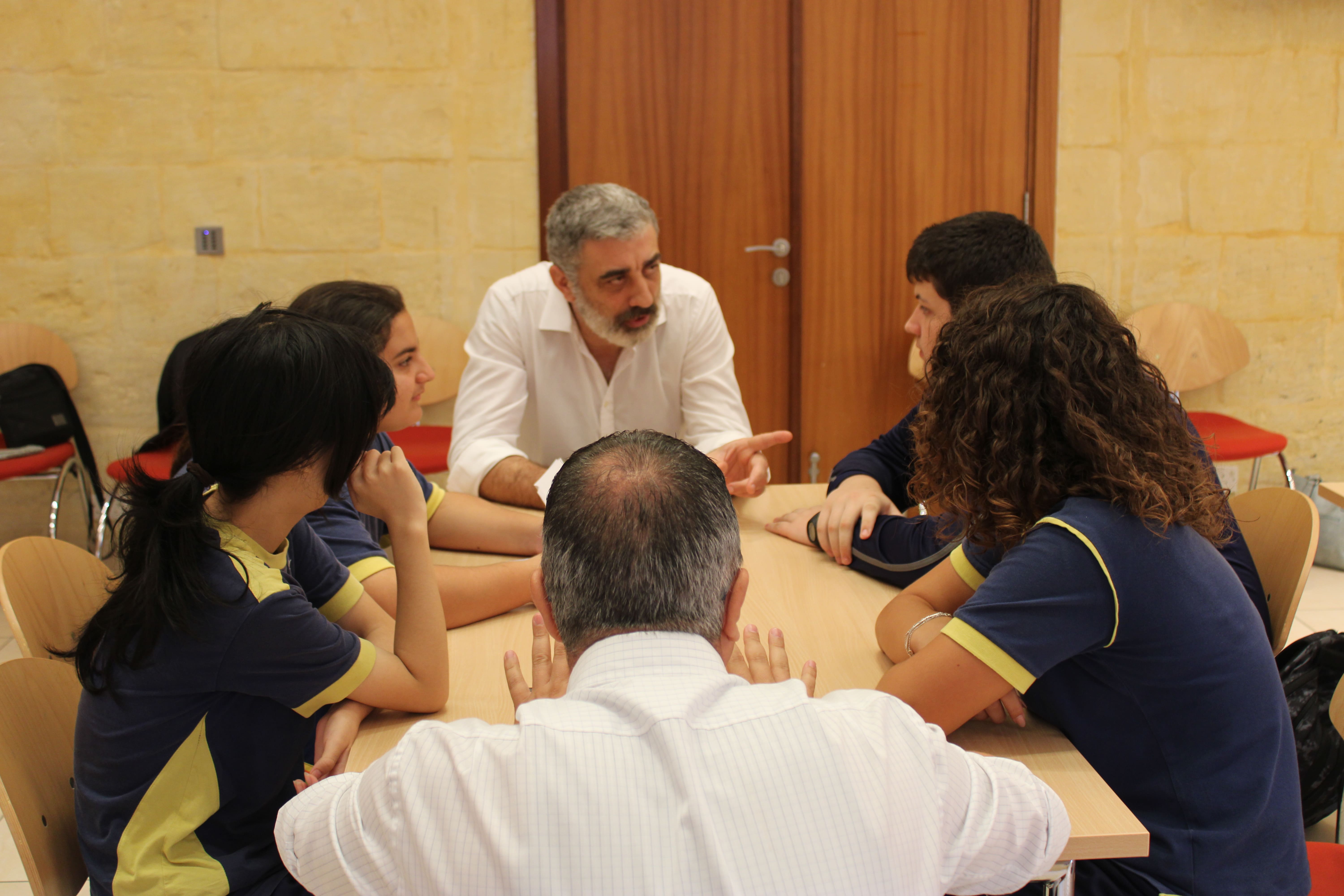 Head of Communications Mark Vella with students, discussing the EU simulation game